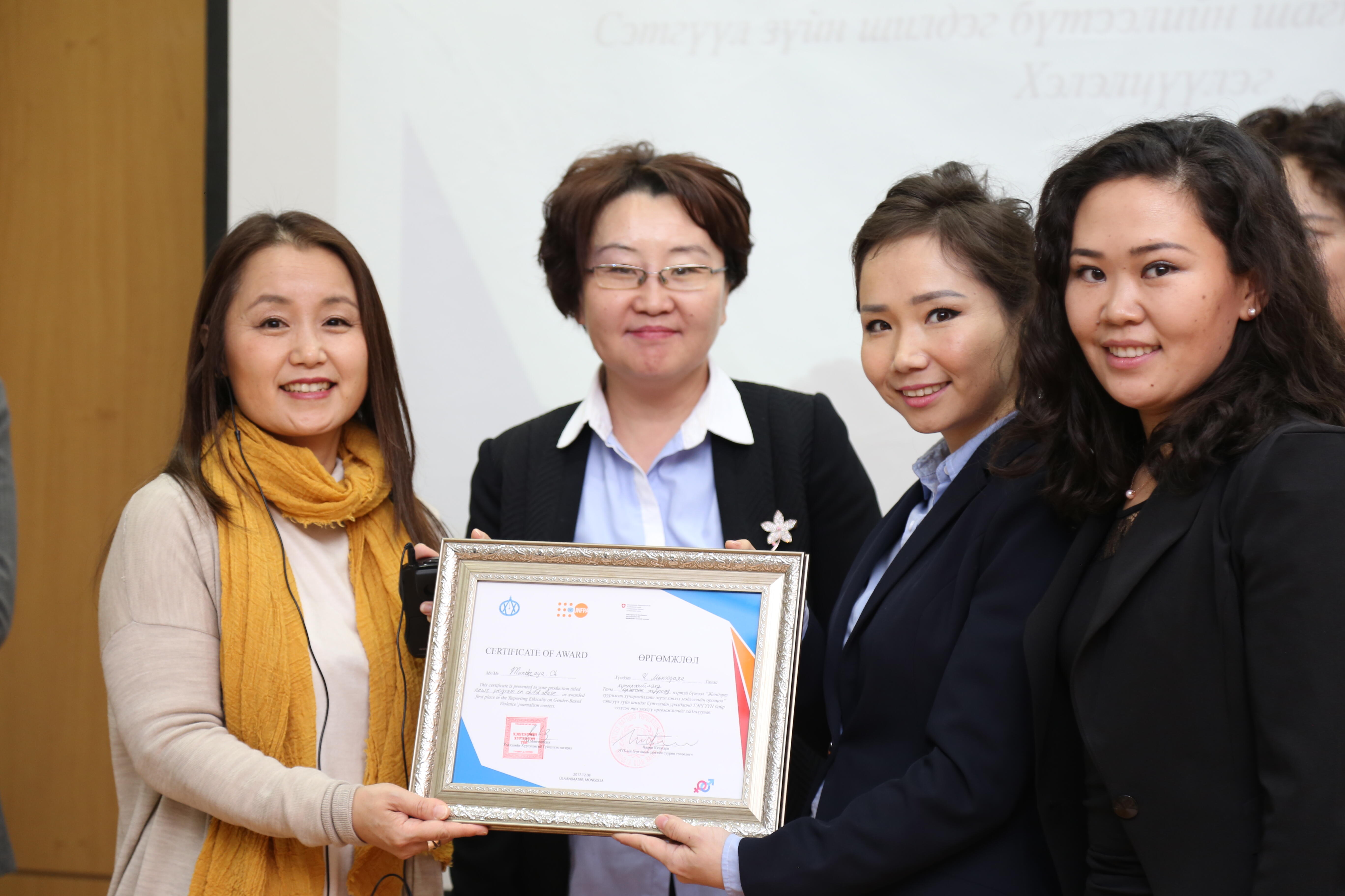 Naomi Kithara (left) and Munkhmandakh (right) pose with the winning journalists from Eagle TV.